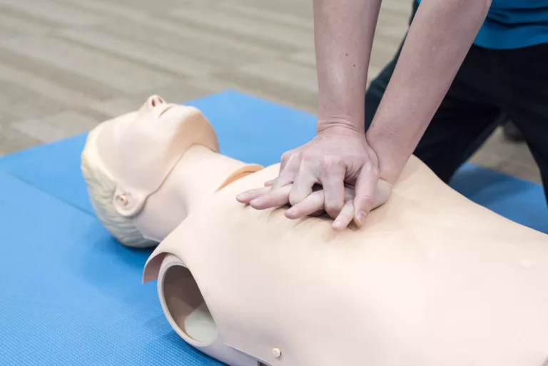 Demonstrating CPR (Cardiopulmonary resuscitation) on a first aid dummy.