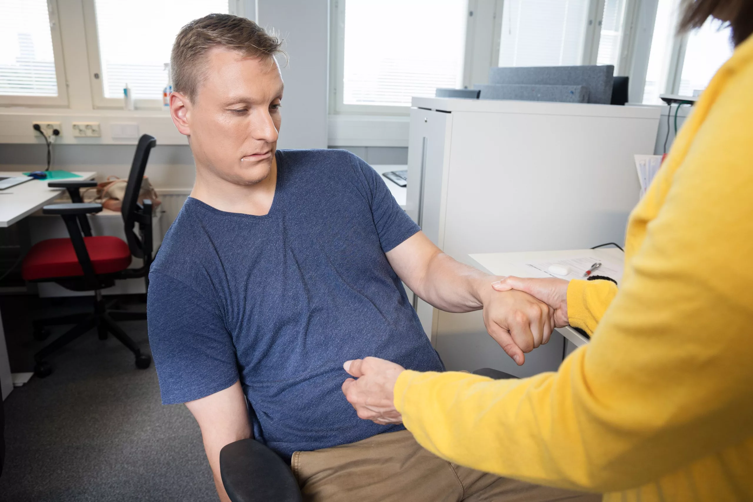 Mannen sitter slapp i en stol och ena sidan av ansiktet hänger ner.