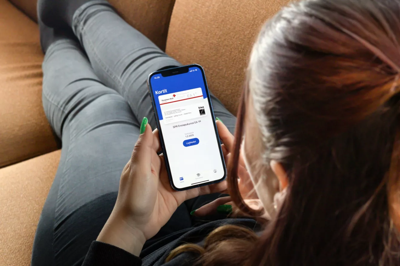 Woman laying down on a couch with their phone, on the screen is the FRC mobile certificate.