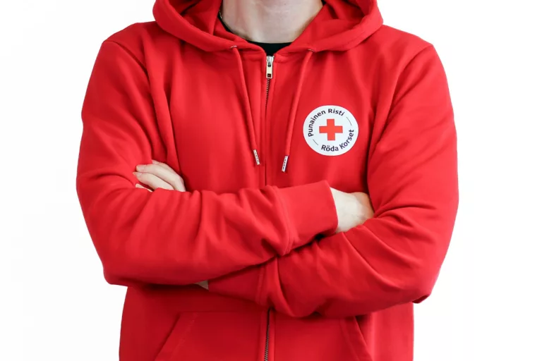 Punainen Risti Ensiapu's employee wearing a red Finnish Red Cross hoodie.