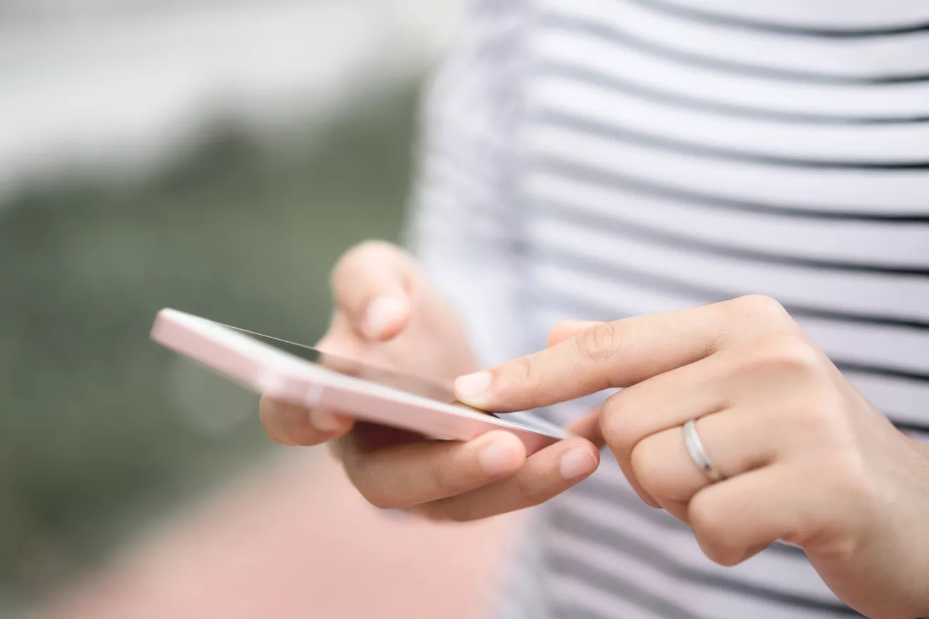 Woman holding a phone. Close up of hands.